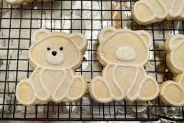 polar bear cookies on a wire rack above an aluminum foil covered baking sheet