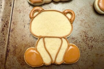 teddy bear cookies outline with brown royal icing and flooded in the ear and feet sections