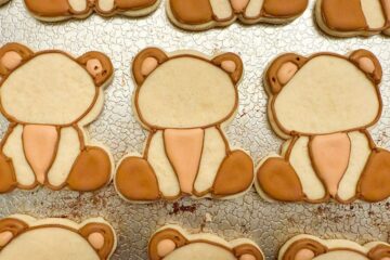 teddy bear cookies with some sections filled with royal icing