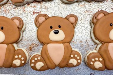 teddy bear cookies with royal icing drying on a cookie sheet