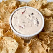 Harry & David Pepper & Onion Relish Dip in a white ramekin with Tostitos scoops around it