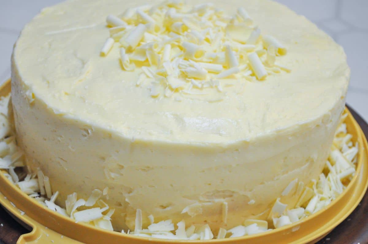 White Chocolate Amaretto Cake with white chocolate curls on top and around the bottom perimeter of the cake