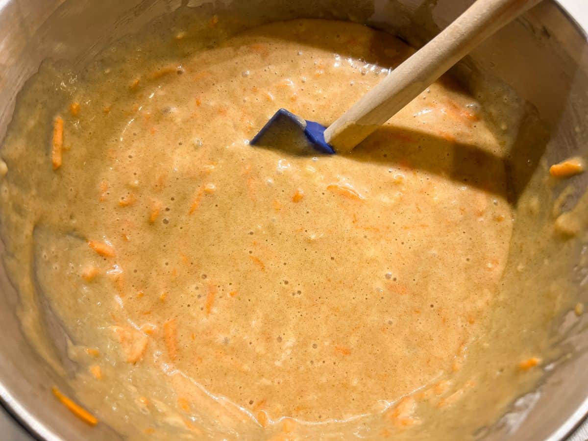 carrot cake batter in a bowl with a rubber spatula