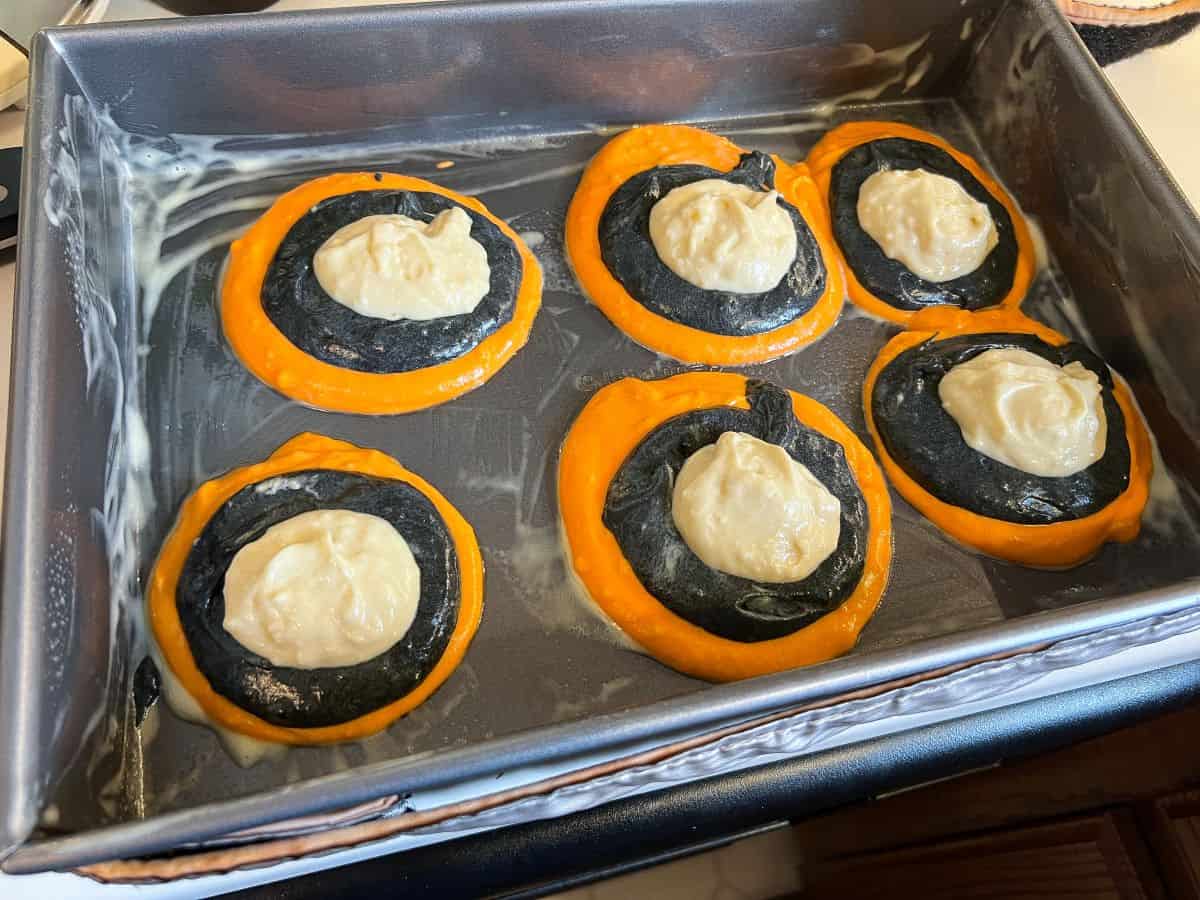 6 circles of cake batter in a rectangular pan