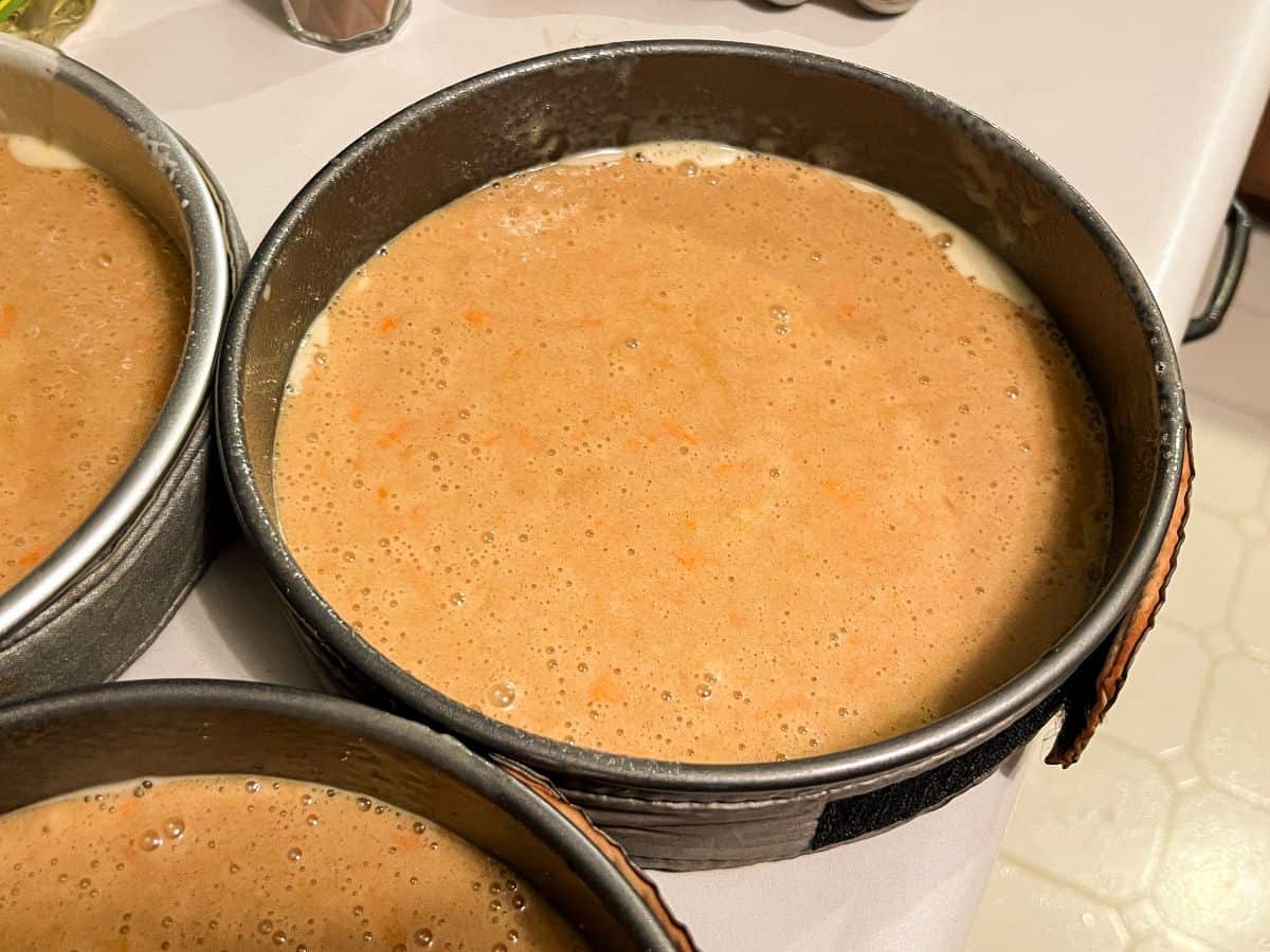 carrot cake batter in 3 round pans before baking