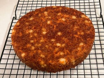 a carrot cake inverted o onto a cooling rack