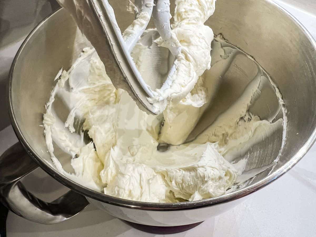 cream cheese frosting in a mixing bowl with a paddle attachment