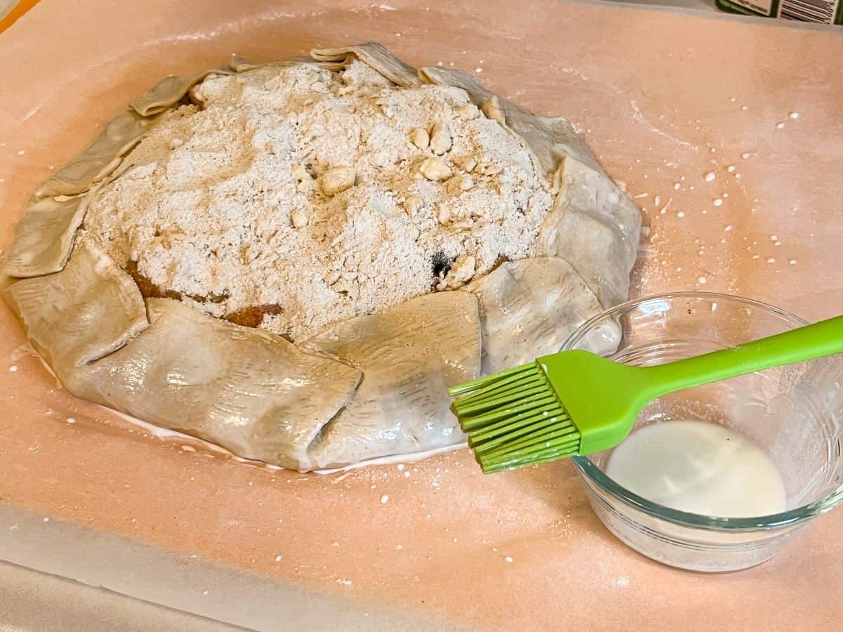 cream brushed on the crust of a rustic tart with a silicone pastry brush