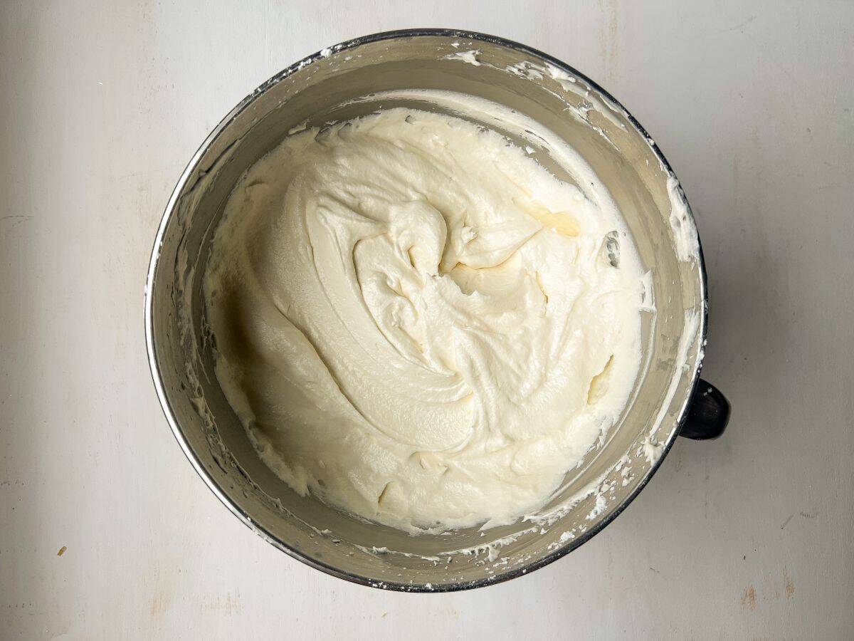 a large mixing bowl full of cream cheese frosting