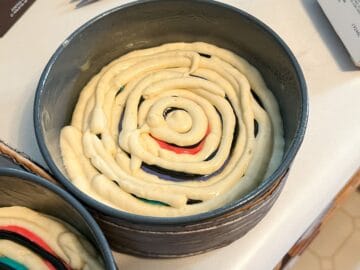 untinted cake batter piped between colors in round cake pan