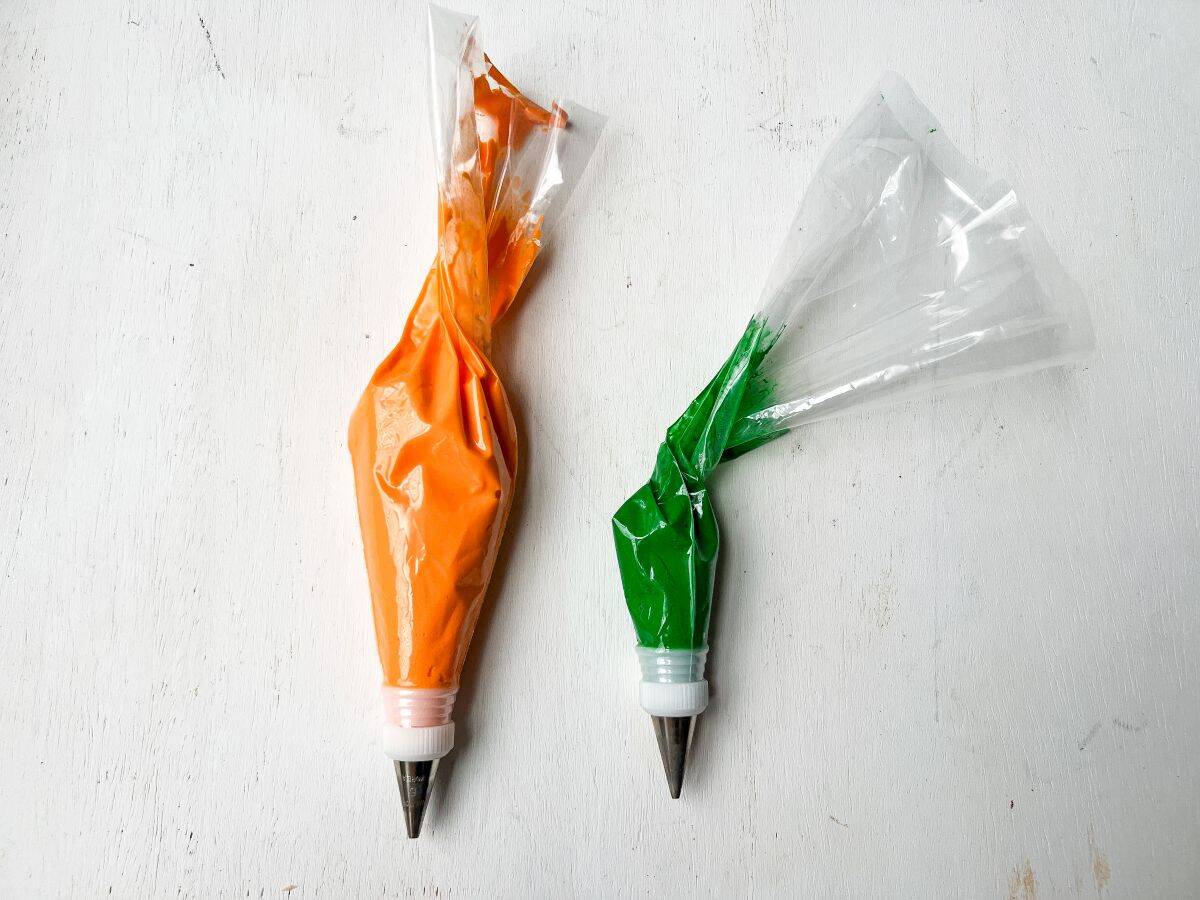 piping bags with orange and green cream cheese frostings