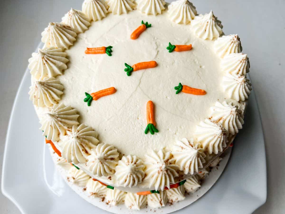 the top of a carrot cake decorated with little cream cheese frosting carrots