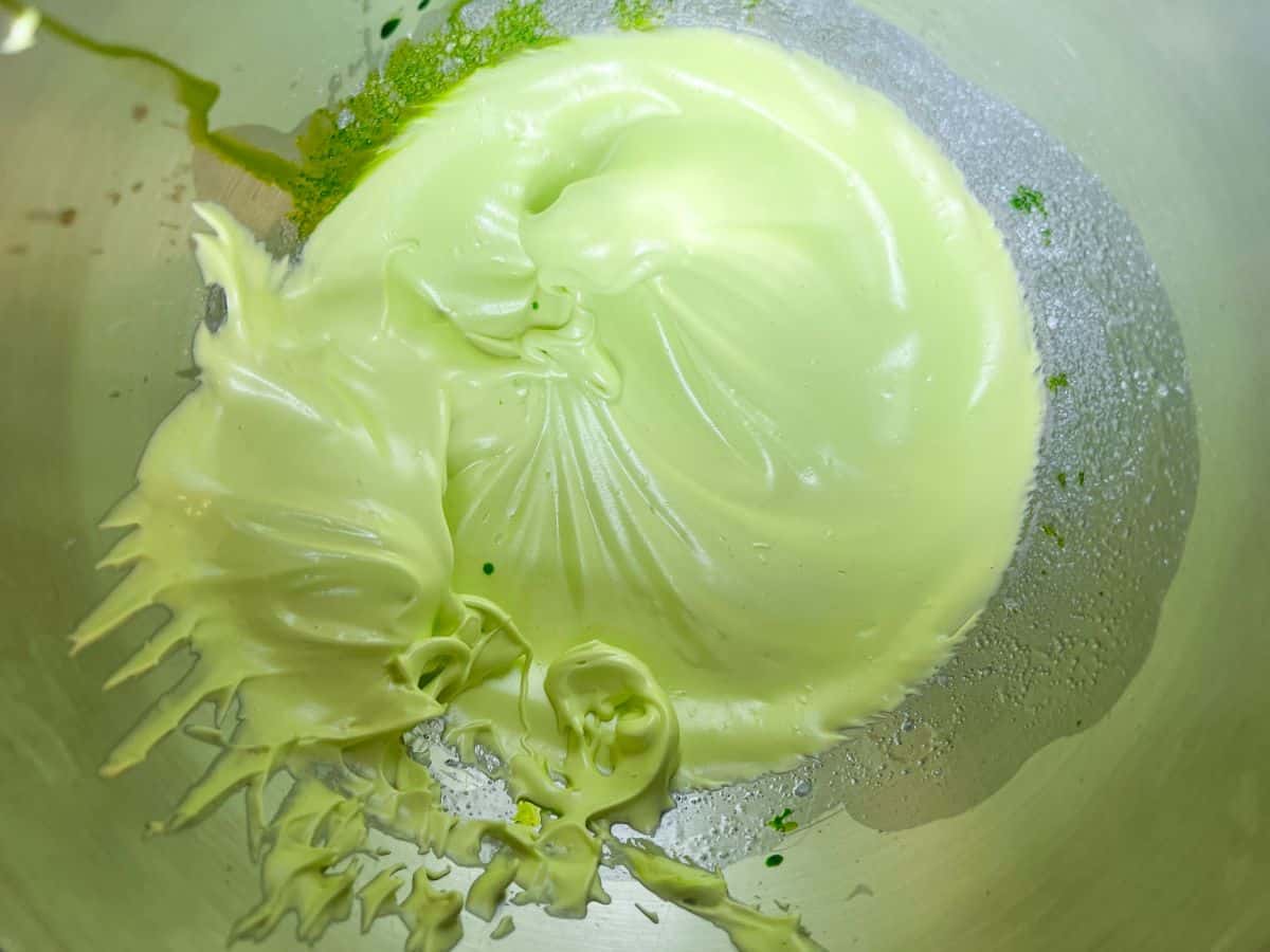 lime green colored meringue in a metal mixing bowl