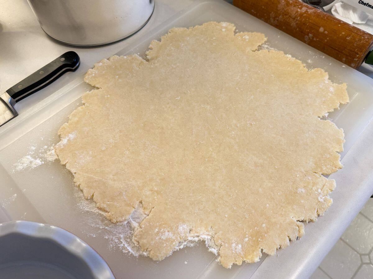 pie dough rolled into a thin layer on a floured cutting board
