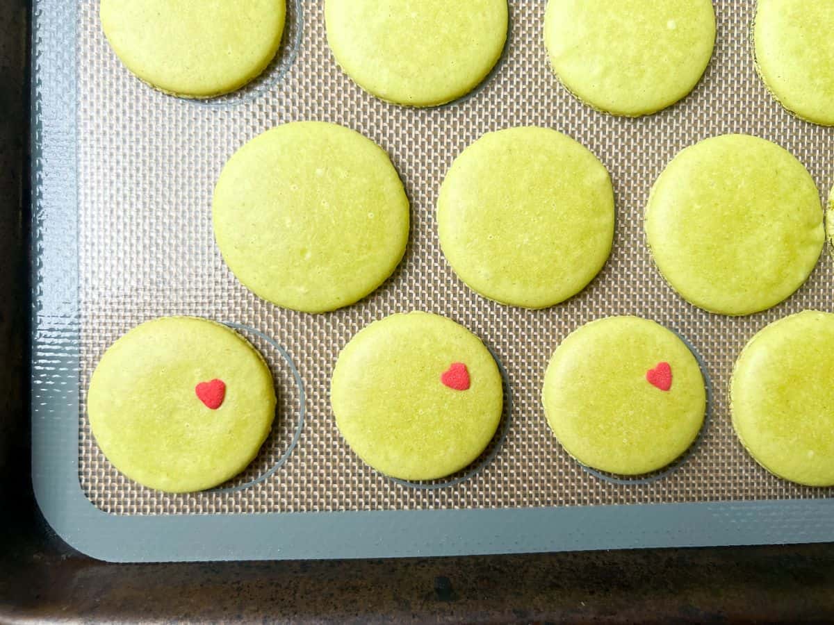 lime green colored macaron shells baked on a macaron mat
