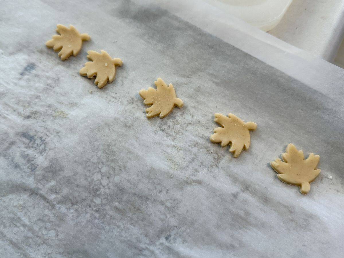 pie crust leaves on a parchment lined cookie sheet before baking