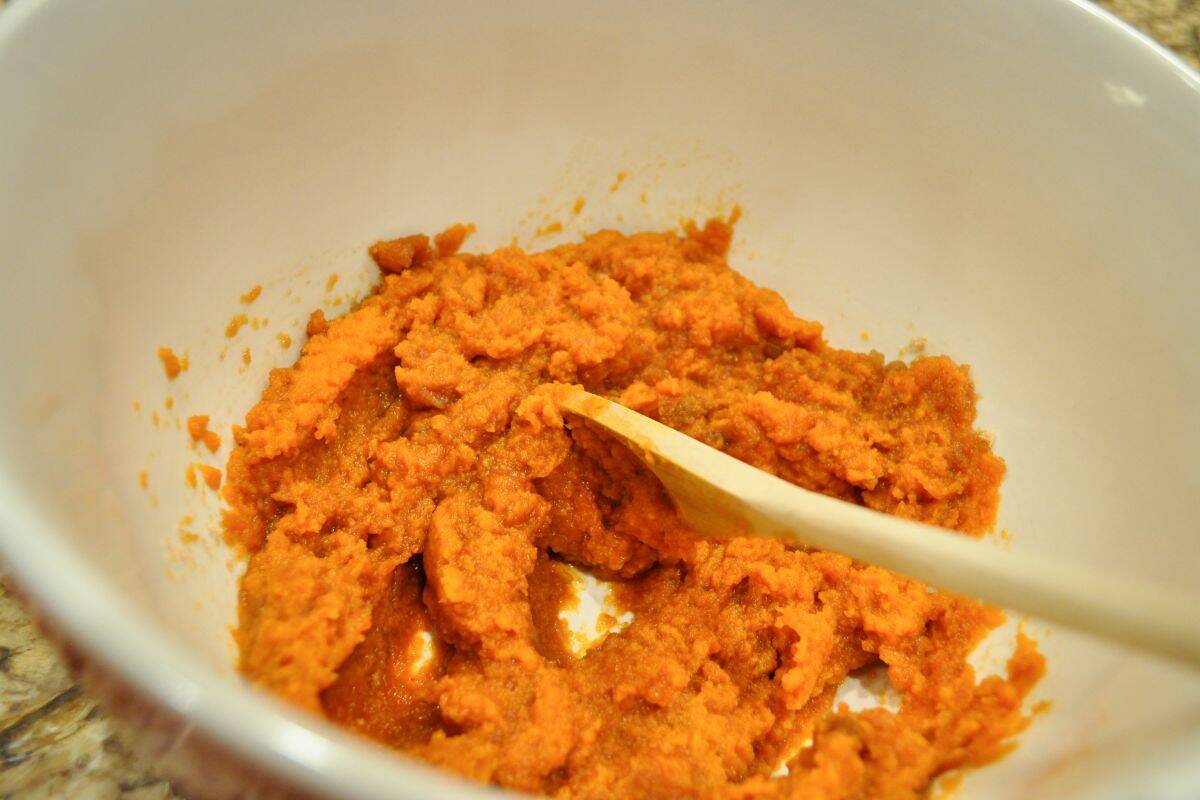 pumpkin puree in a bowl with a wooden spoon