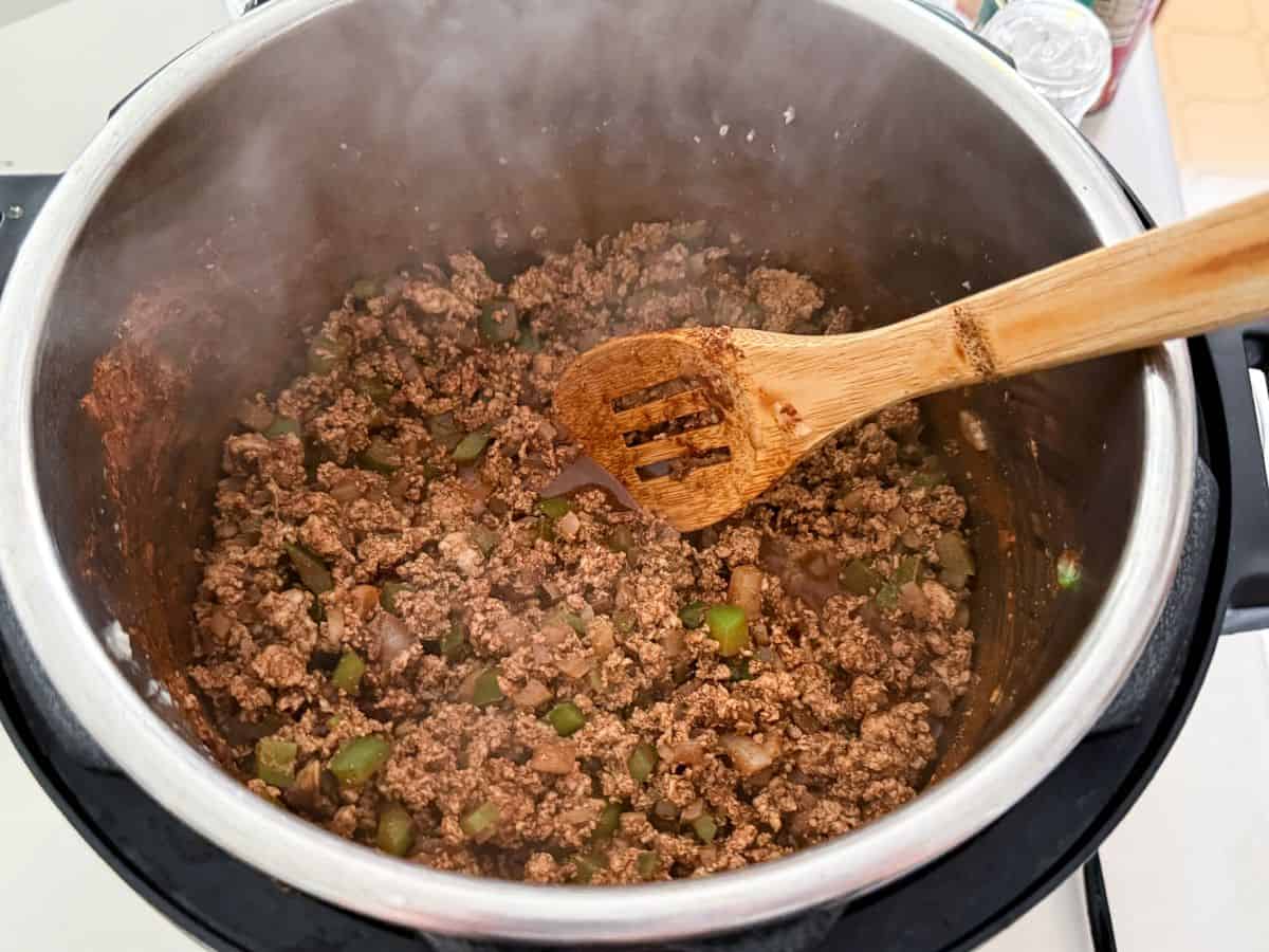 an instant pot with ground turkey and veggies mixed with spices and cocoa powder