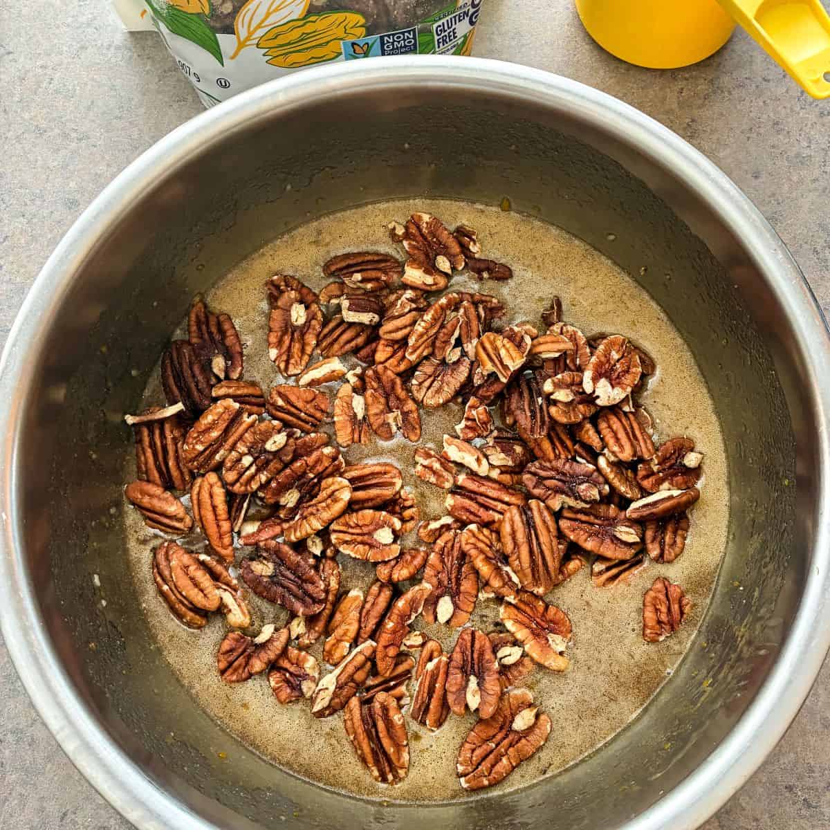 pecans dumped into a bowl of pecan pie filling