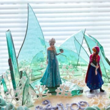 Elsa's Ice Candy with Anna and Elsa figurines on top of a cake