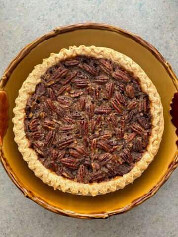 Famous Pecan Pie in a ceramic pie plate on a countertop