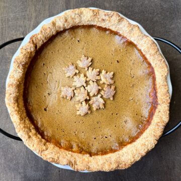 a pumpkin pie with cinnamon sugar leaf shapes on top to decorate