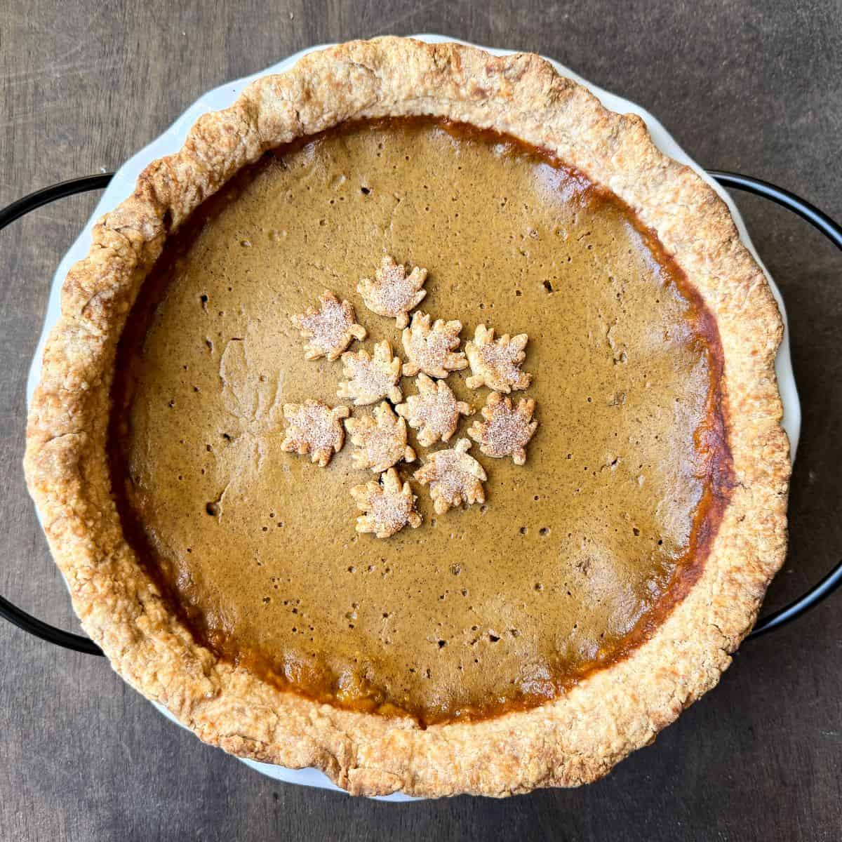 a pumpkin pie with cinnamon sugar leaf shapes on top to decorate