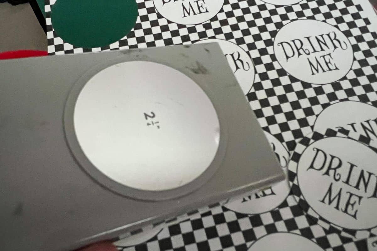 a 2 ¼ inch circular punch cutting out drink labels