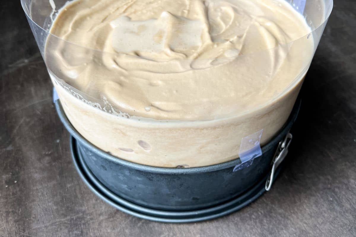 coffee ice cream on top of a Ghirardelli caramel layer of an ice cream cake in a round springform pan