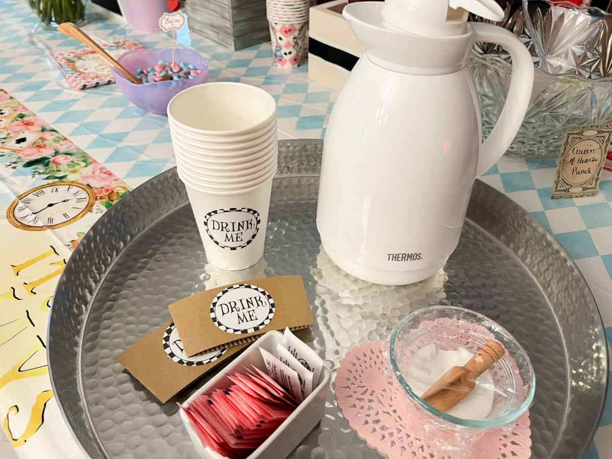 white paper coffee cups with "Drink Me" labels on them