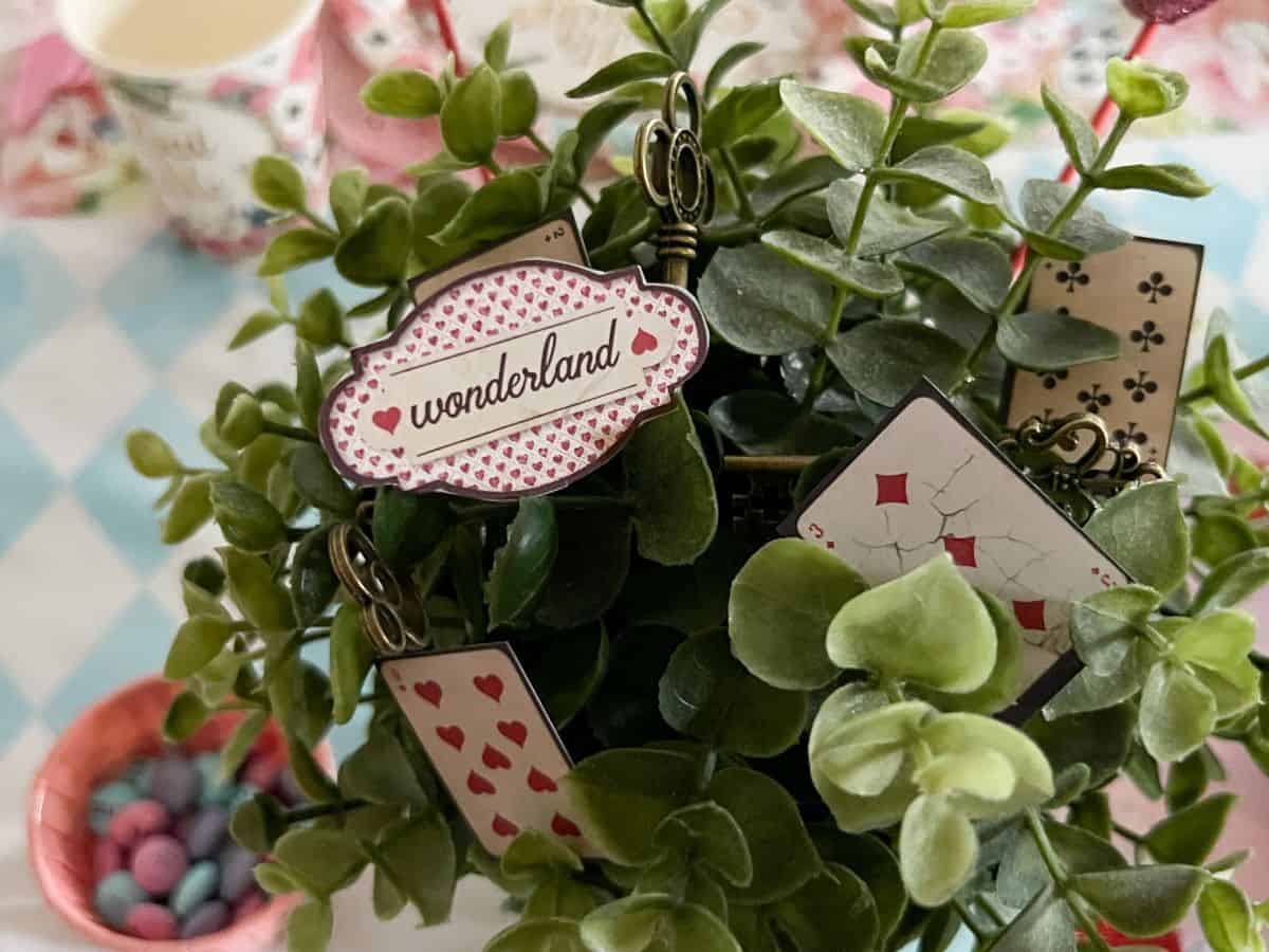 paper "wonderland" scrapbook pieces in a faux plant