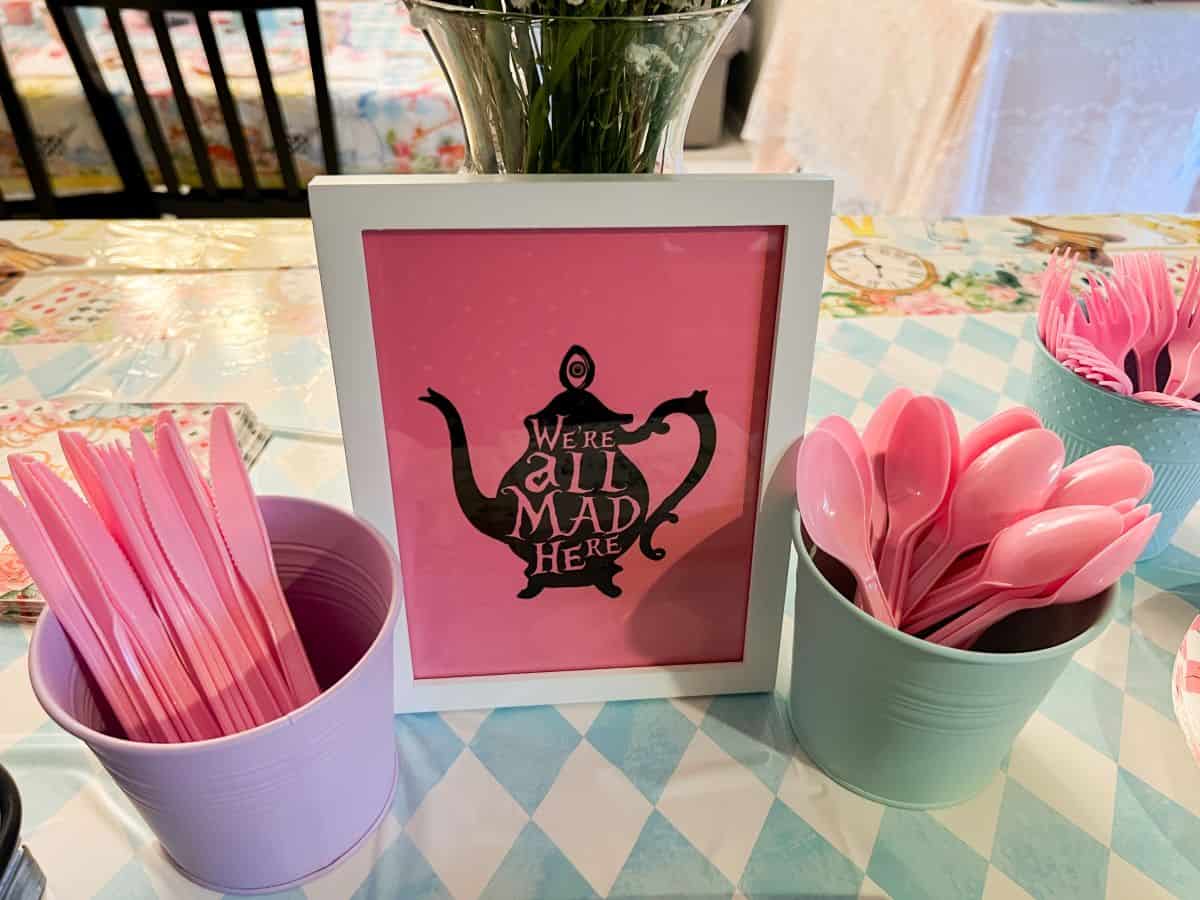 a tea pot printed on pink cardstock in a frame on a serving table