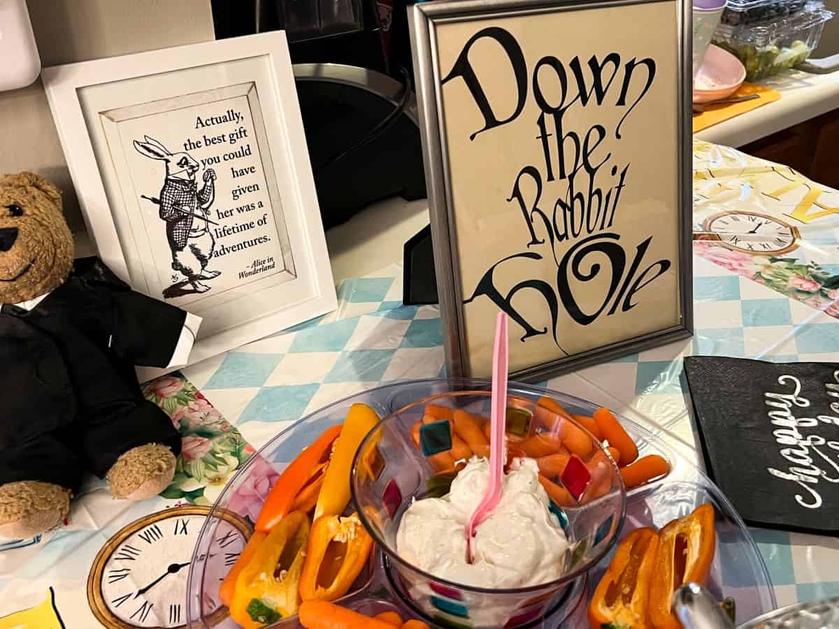 Alice in Wonderland printables in frames next to a veggie tray