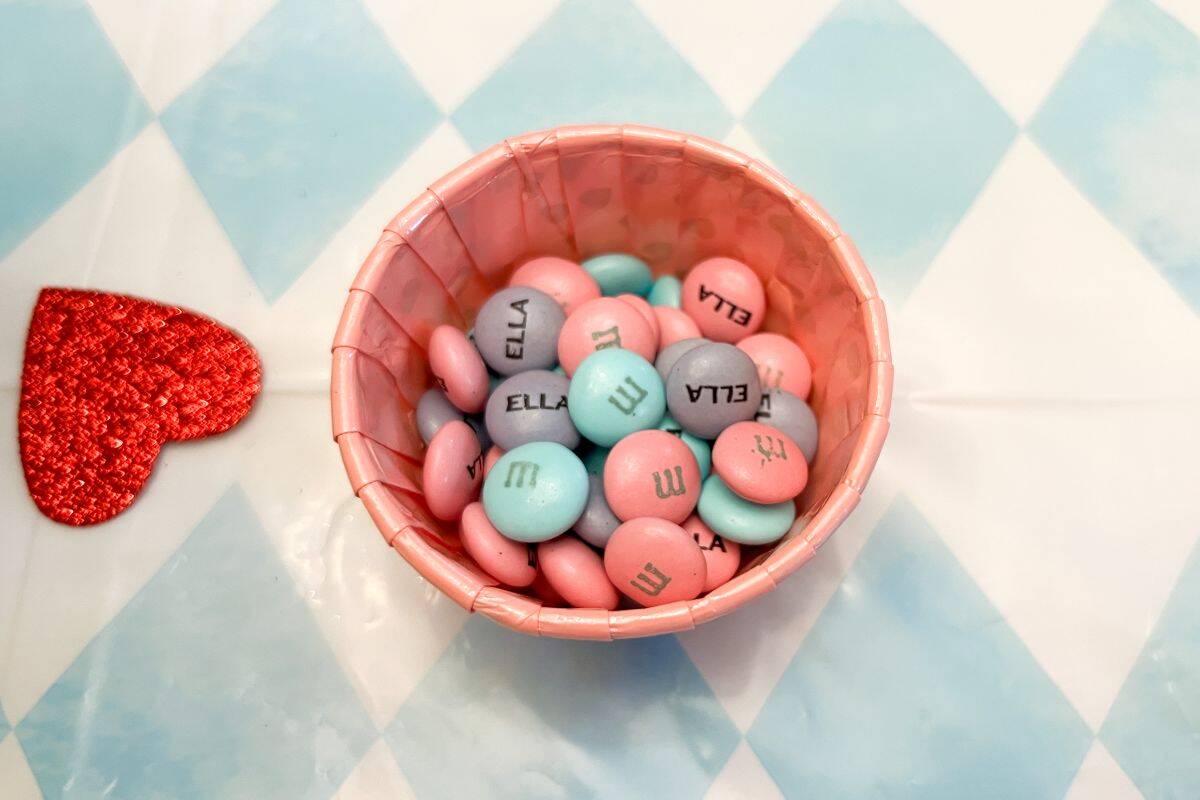 personalized M&M's in a pink paper cup on a table
