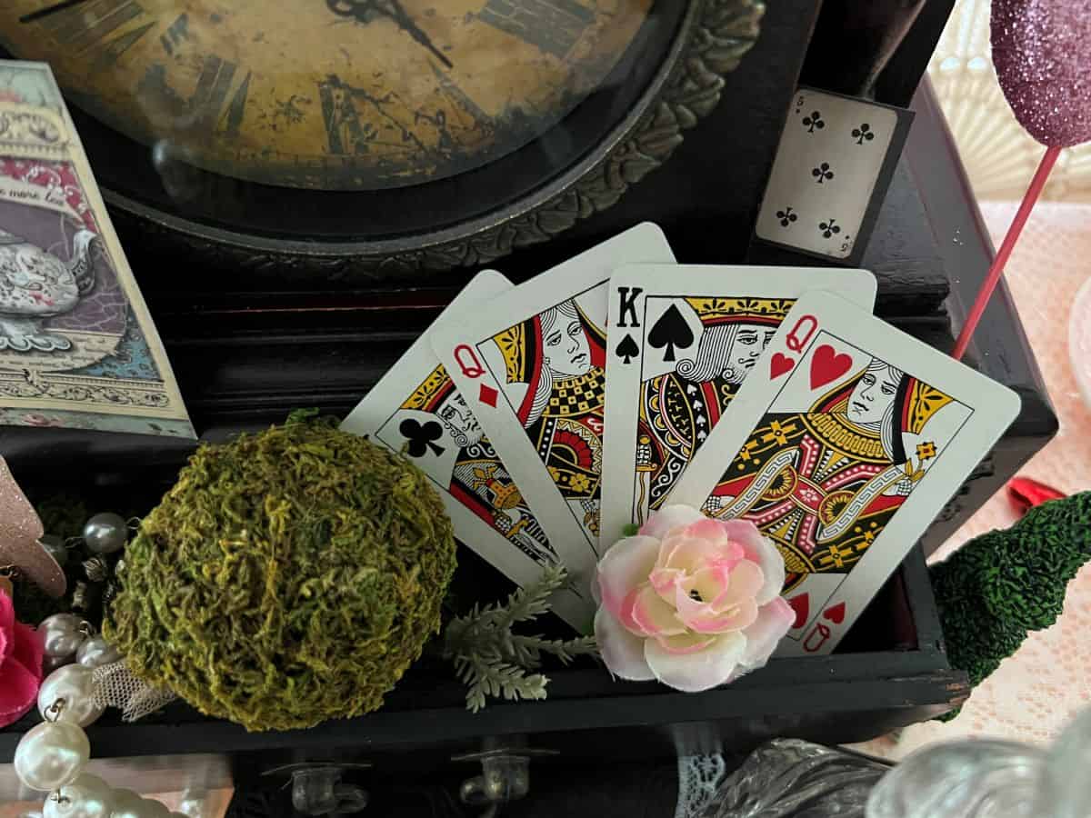 playing cards splayed out in the drawer of a wooden antique clock
