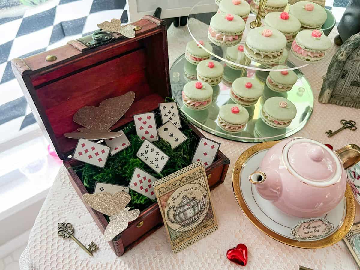 a small wooden box filled with faux moss and tiny cardstock playing cards