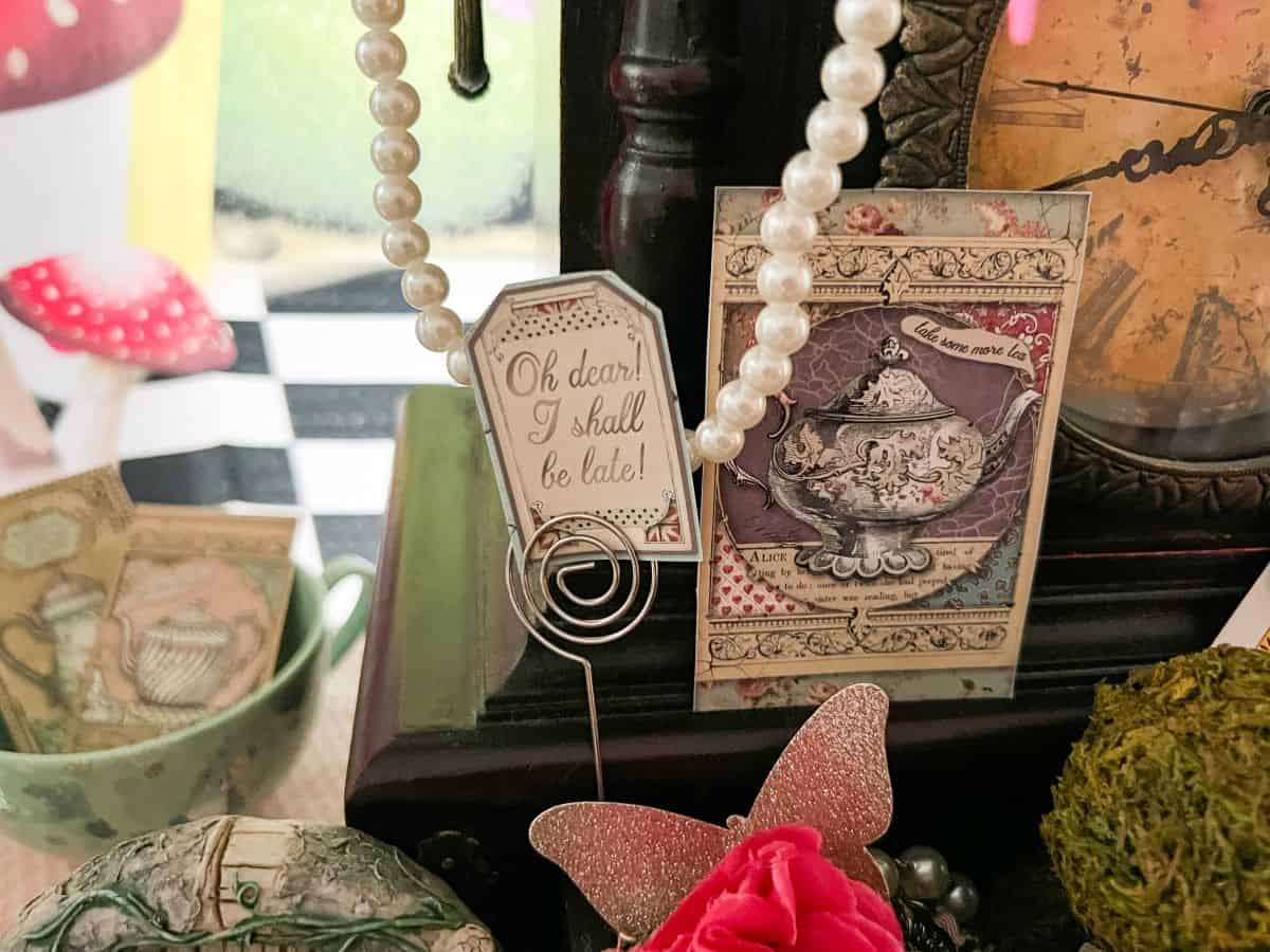 vintage Alice in Wonderland cardstock cutouts displayed in an antique clock