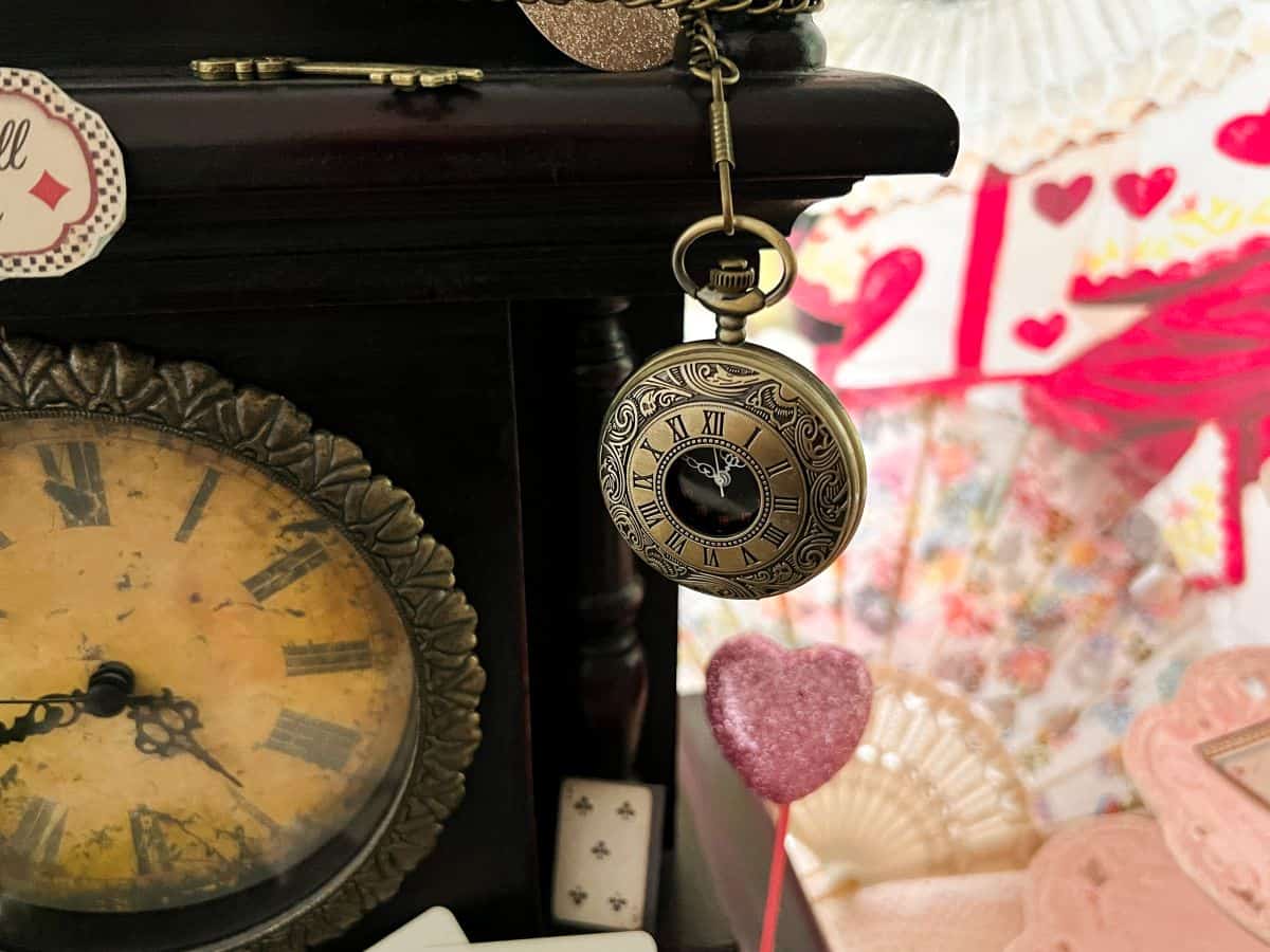 a pocket watch hanging from an antique clock