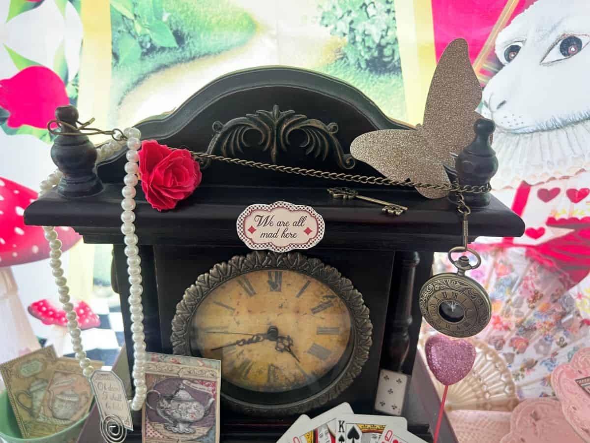a wooden antique clock decorated for an Alice in Wonderland theme