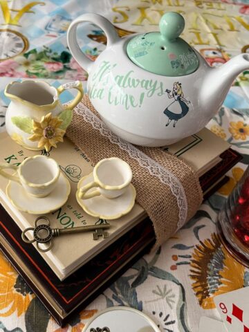 Books stacked with small teacups and a small teapot