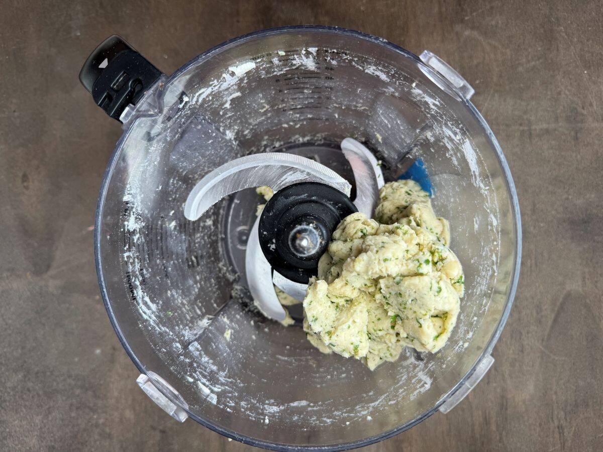 tart dough coming together in the bowl of a food processor