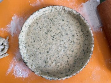 basil tart dough fitted into a tart pan