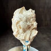Easy Coffee Buttercream on a spatula held up over a bowl