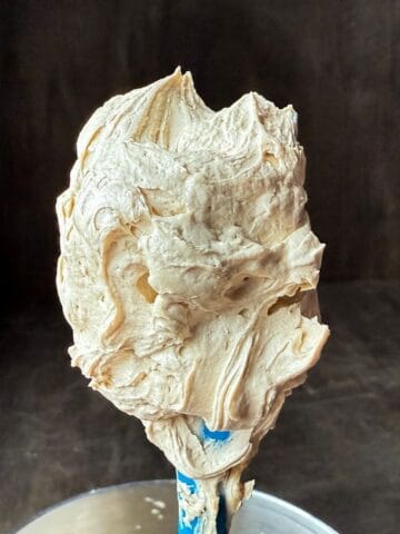 Easy Coffee Buttercream on a spatula held up over a bowl