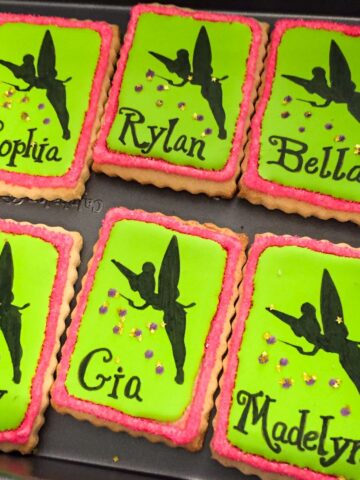 Tinkerbell cookies with black Tinkerbell silhouettes sprinkling pixie dust