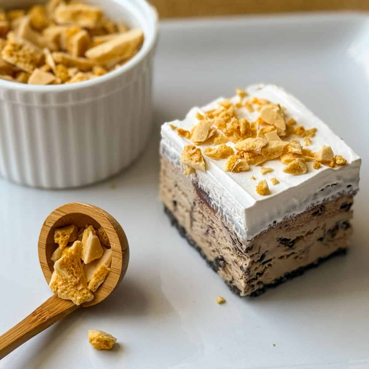 coffee crunch candy on top of a piece of ice cream cake