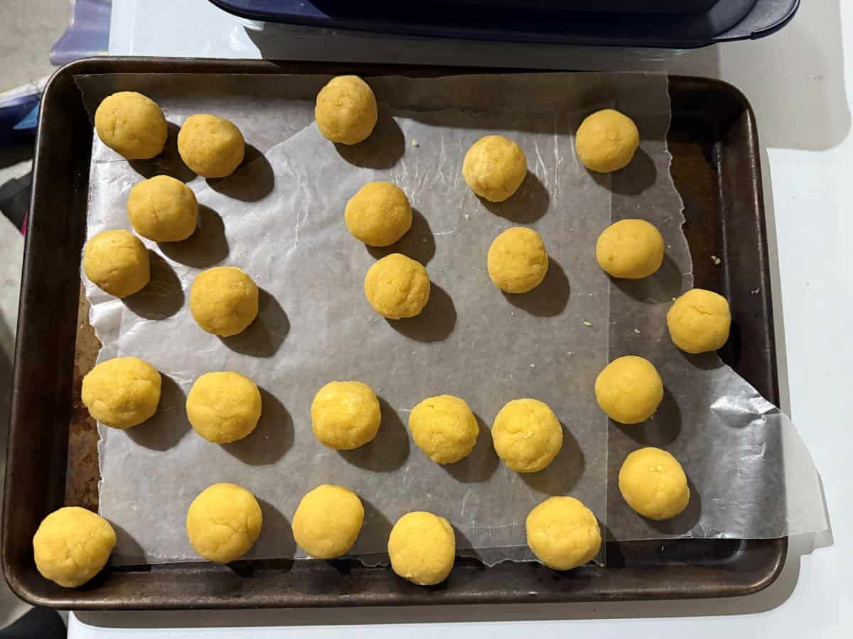 balls of cake on a waxed paper lined baking sheet