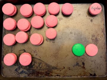 macaron shells paired up by size on a baking sheet