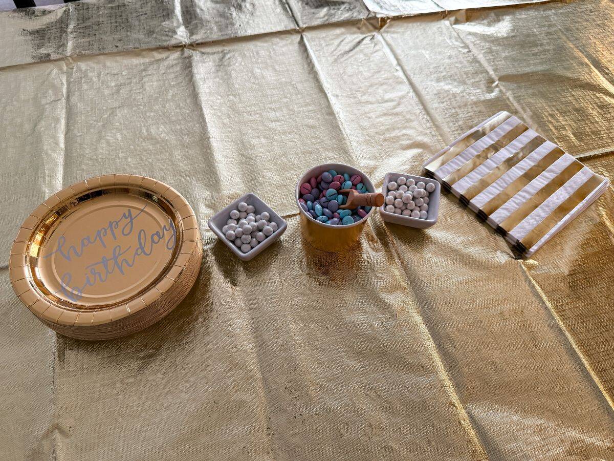 gold paper plates and napkins on a gold tablecloth covered table