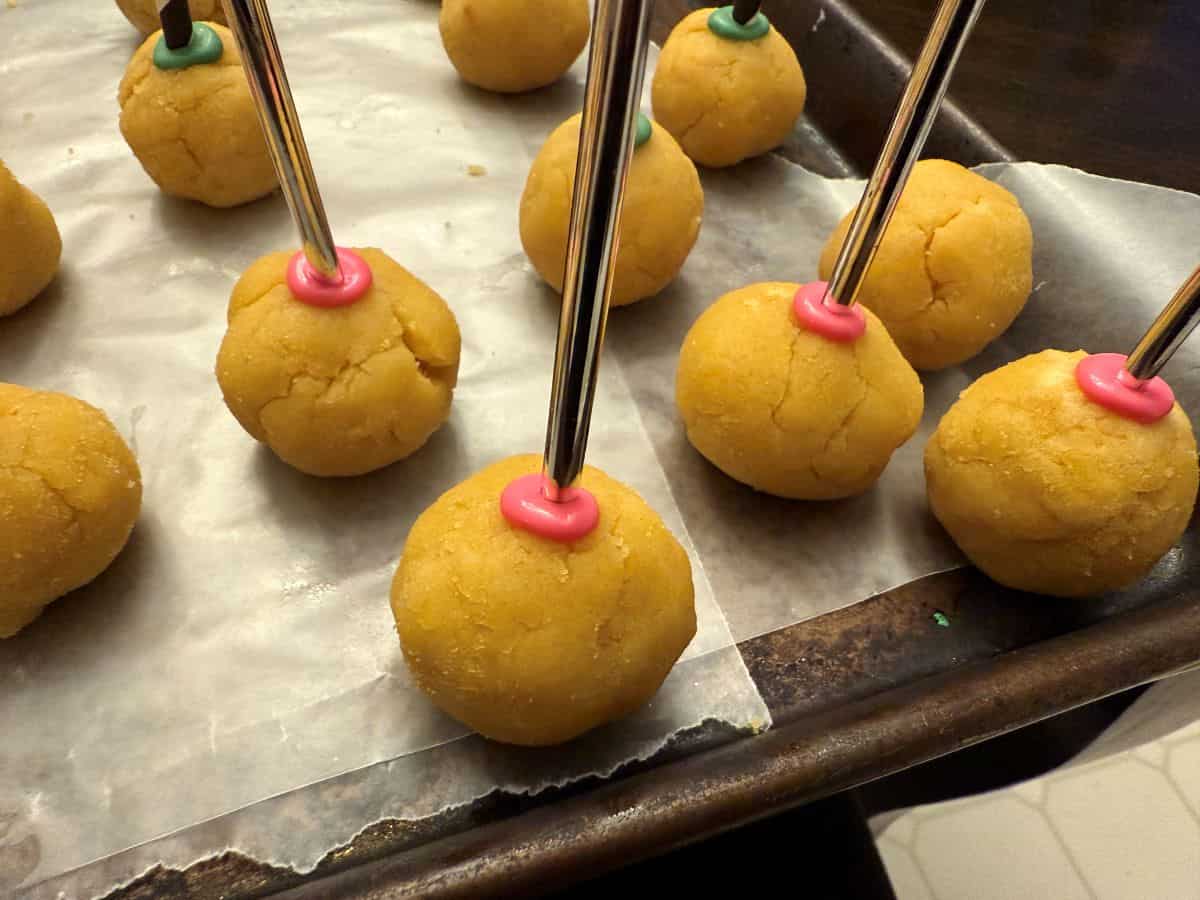 silver wands stuck into cake pops with melted bright pink candy melts